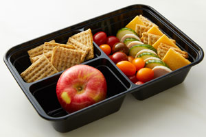 Bento box with cracker cuts, crackers, apple, tomatoes, cucumbers, turkey